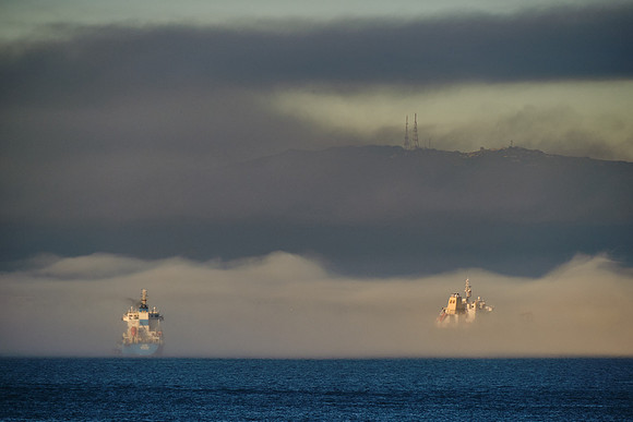 Smoke from a large Spanish fire layers over sea fog