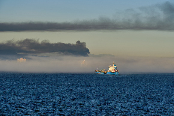 Smoke from a large Spanish fire layers over sea fog